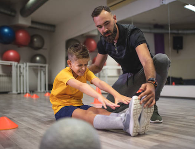 Physical therapist helping a boy stretch