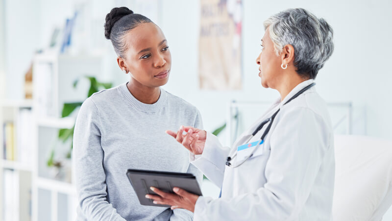 Woman looking at and listening to her doctor