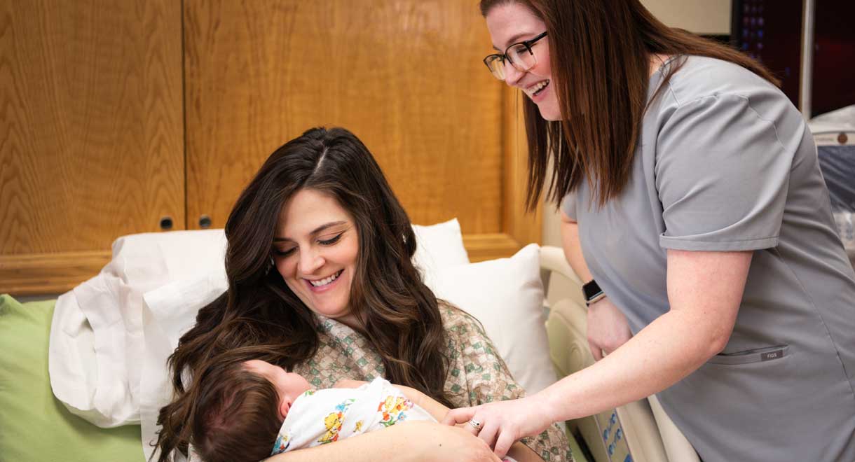 Mother with newborn baby with staff member