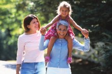 Active senior carrying child on shoulders